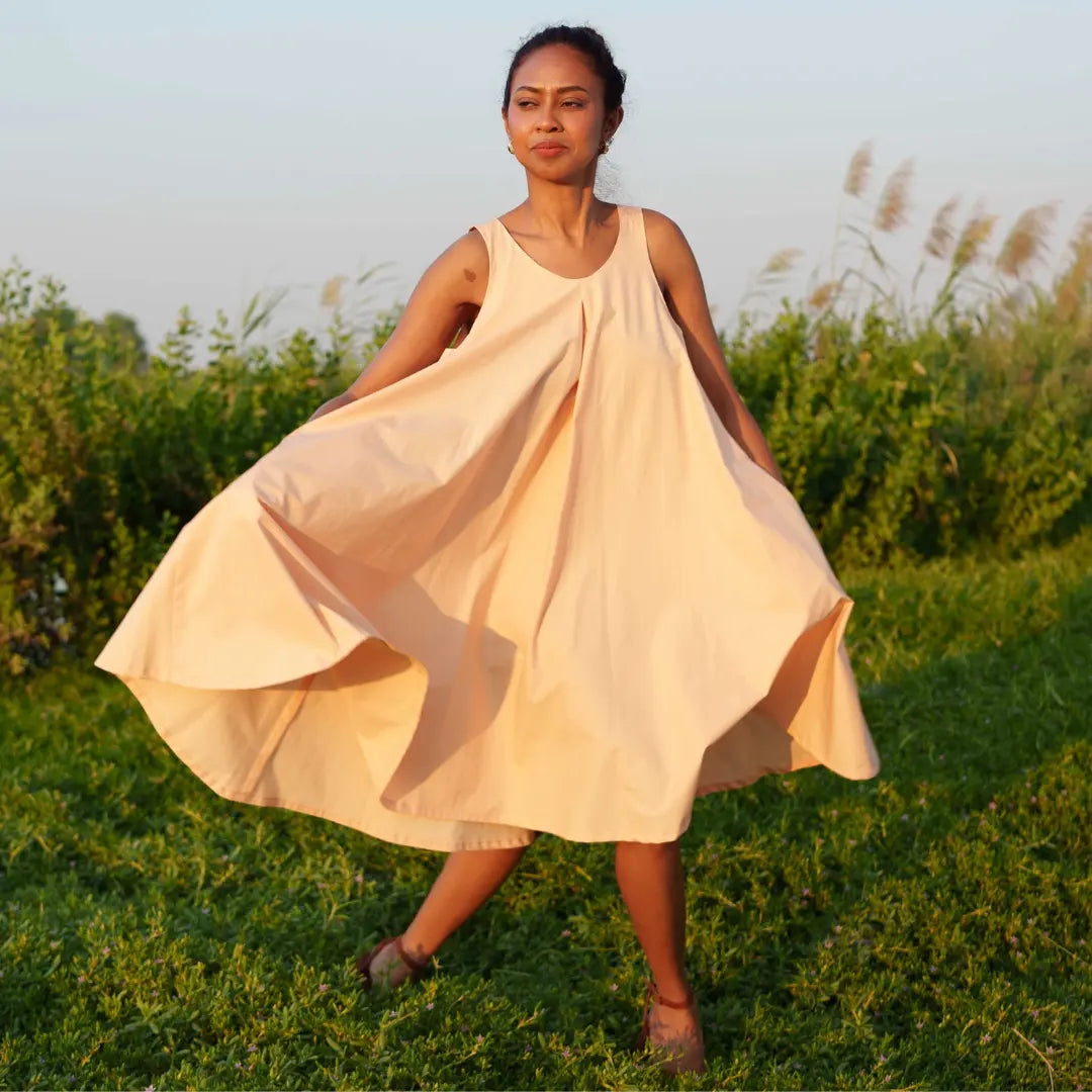 Knee-length dress in gentle peach is crafted from GOT- Certified organic cotton. SUSTAINABLY U.