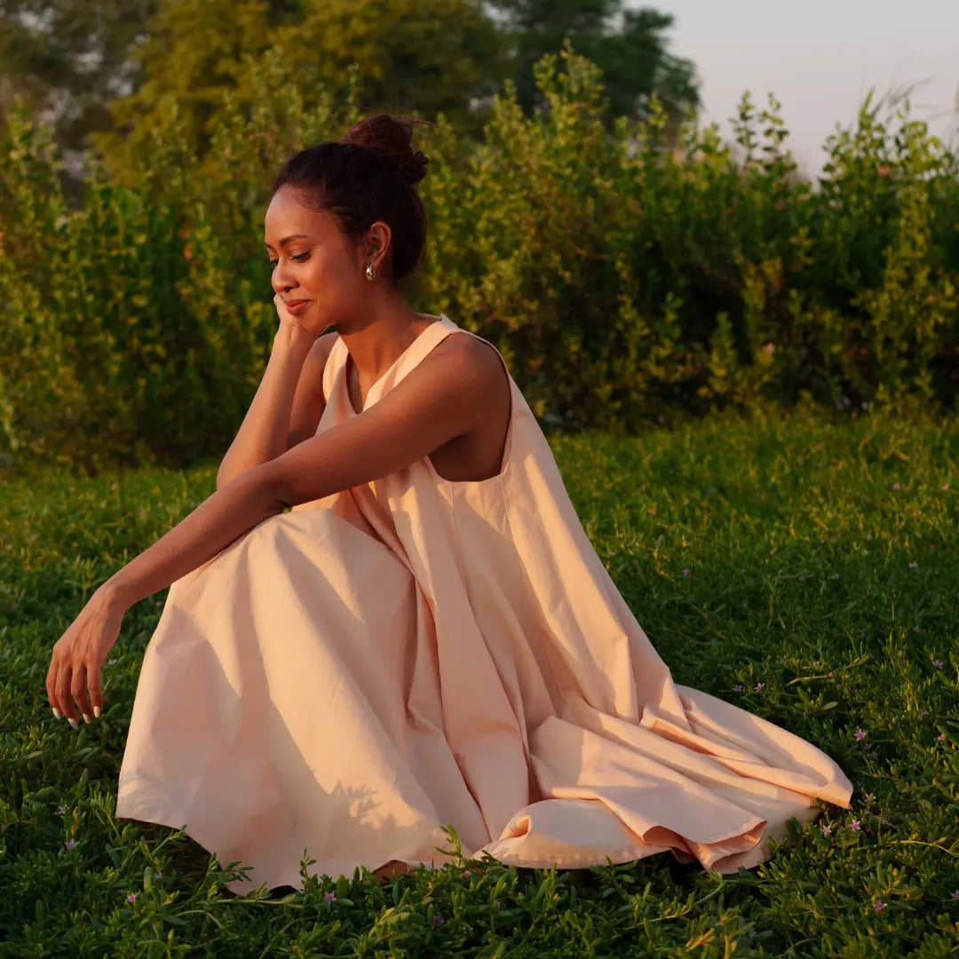 Knee-length dress in gentle peach is crafted from GOT- Certified organic cotton. SUSTAINABLY U.