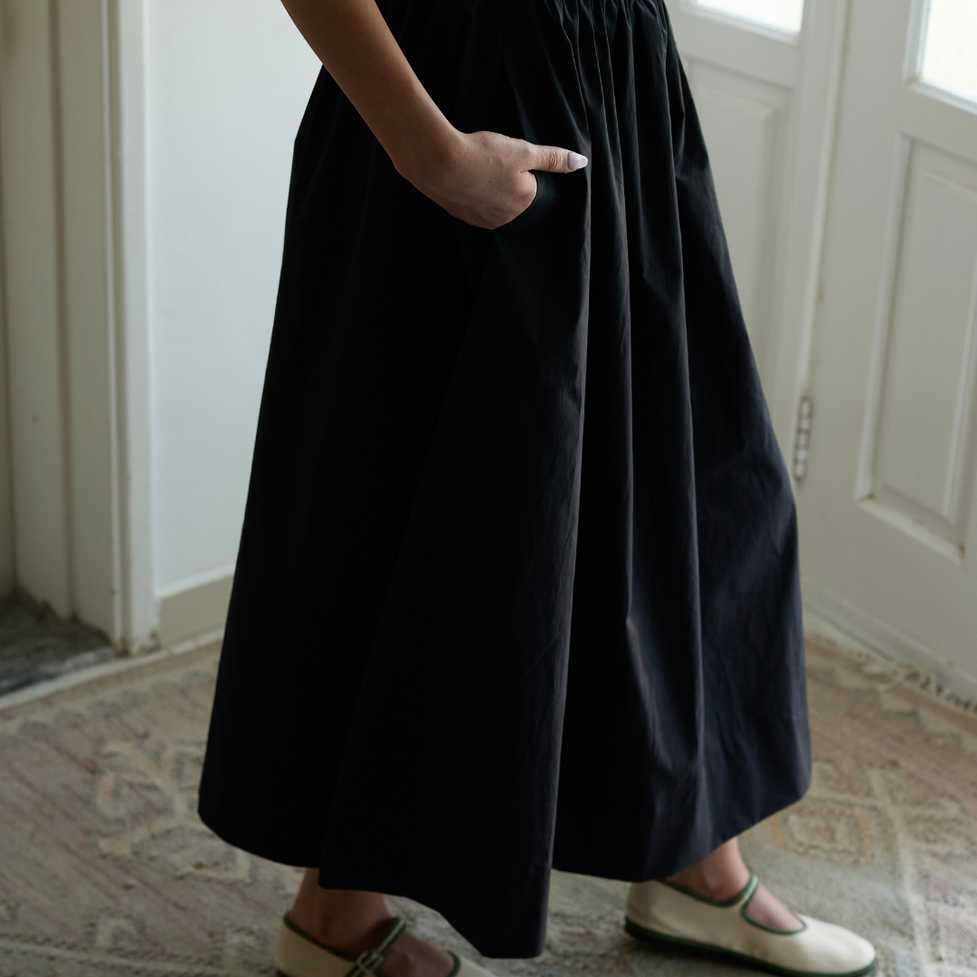 Shama organic cotton midi skirt styled in black, full-length view