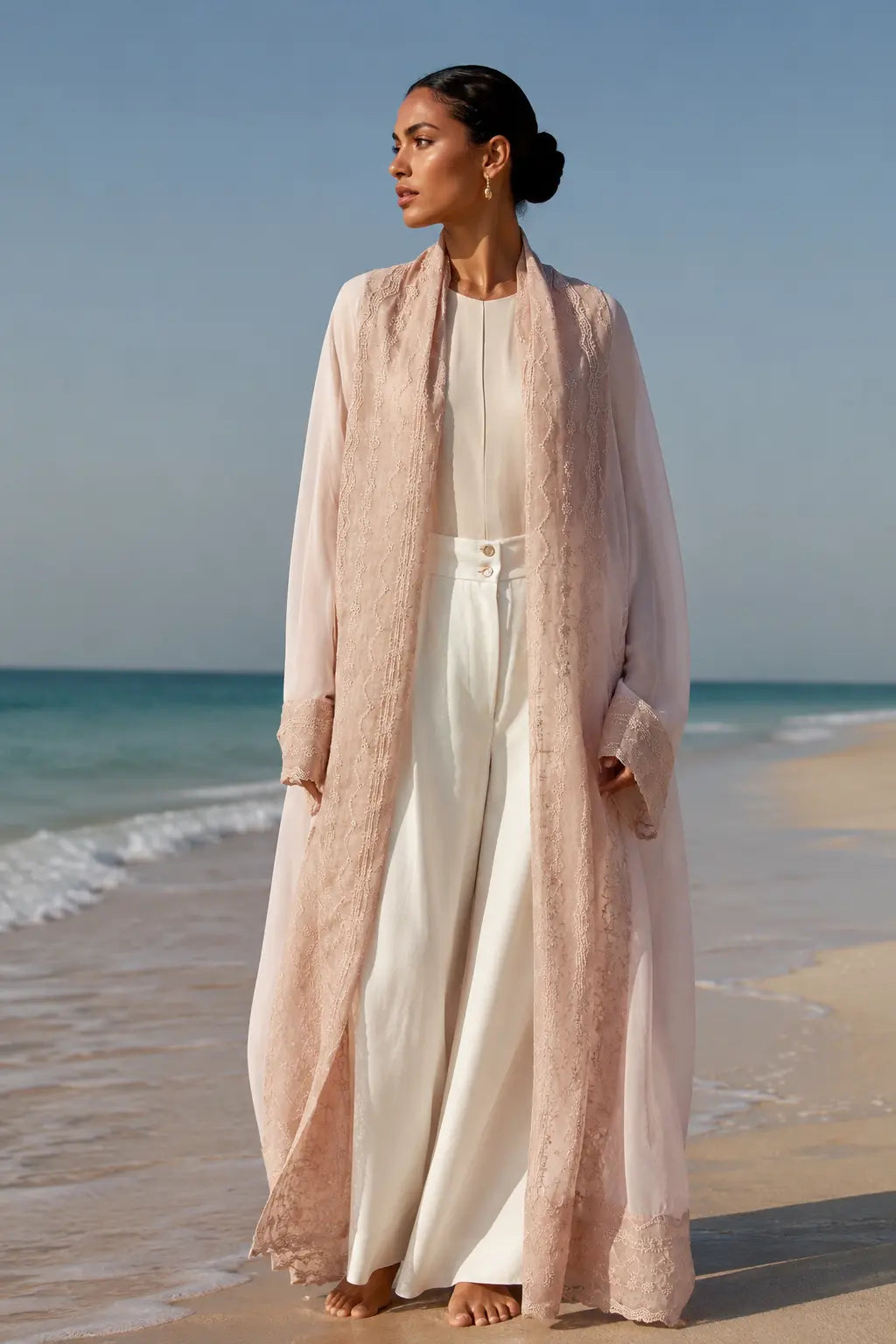 An oversized, floor-length shawl abaya crafted from premium Italian linen, featuring soft pastel hues and delicate thread work trim along the neckline, sleeves, and hem.